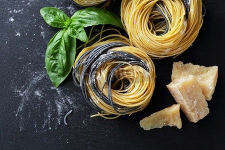 Spaghetti schwarz_gelb mit Parmesan und Basilikum dekoriert